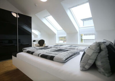 Double bed with wardrobe White wall with skylight