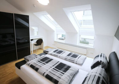 Double bed with wardrobe White wall with skylight